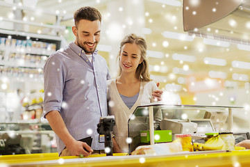 Image showing couple buying food at grocery store cash register