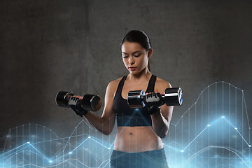 Image showing young woman flexing muscles with dumbbells in gym