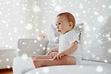 Image showing happy baby boy or girl sitting on sofa at home