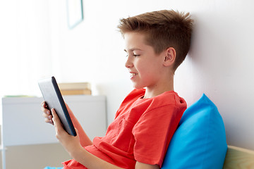 Image showing smiling boy with tablet pc computer at home