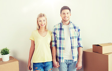 Image showing smiling couple with big boxes moving to new home