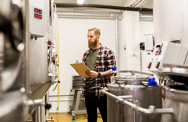 Image showing man with clipboard at craft brewery or beer plant