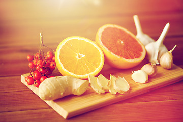 Image showing citrus, ginger, garlic and rowanberry on wood