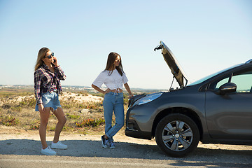 Image showing Girls with a broken a car on country road