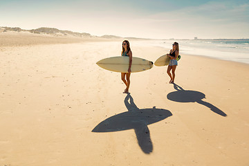 Image showing Surfer girls walking on the beach