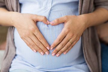 Image showing close up of pregnant woman making heart on belly