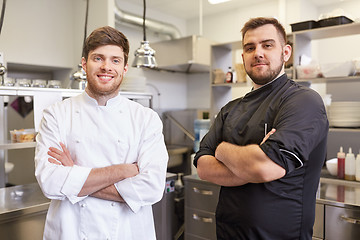Image showing happy smiling chef and cook at restaurant kitchen