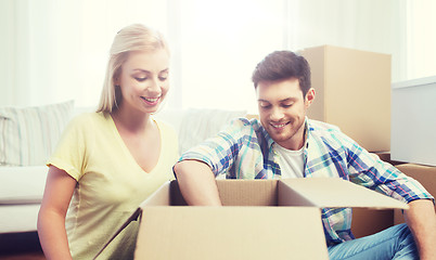 Image showing smiling couple with big boxes moving to new home