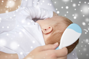 Image showing close up of mother brushing newborn baby hair