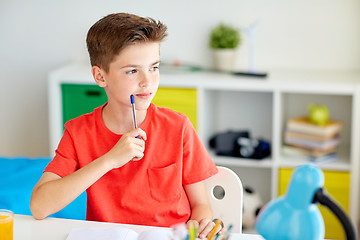 Image showing student boy with pen and notebook thinking at home