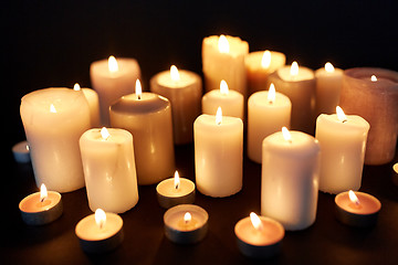 Image showing candles burning in darkness over black background