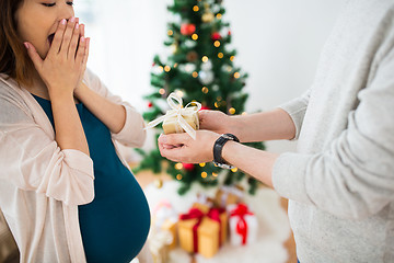 Image showing husband giving christmas present to pregnant wife