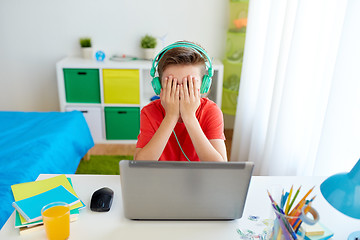 Image showing boy in headphones playing video game on laptop