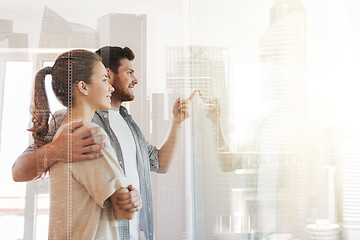 Image showing happy couple looking through window at new home