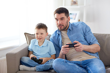 Image showing father and son playing video game at home