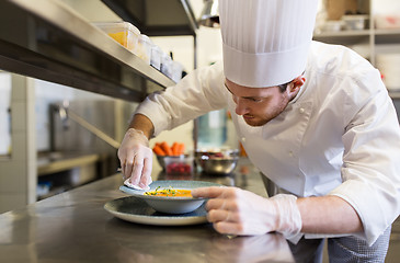 Image showing happy male chef cooking food at restaurant kitchen