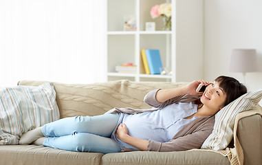 Image showing happy pregnant woman calling on smartphone at home