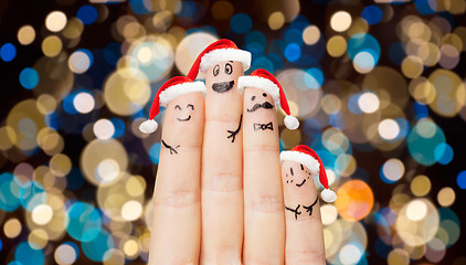 Image showing close up of fingers in santa hats at christmas