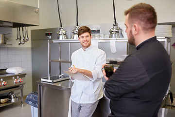 Image showing happy smiling chef and cook at restaurant kitchen