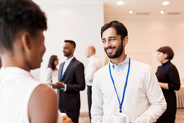 Image showing business people with conference badges and coffee