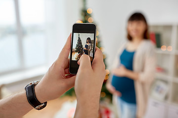Image showing husband photographing pregnant fife at christmas