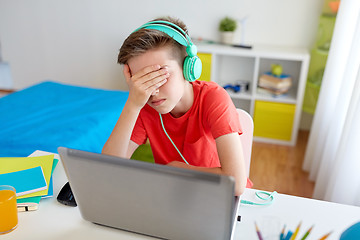 Image showing boy in headphones playing video game on laptop