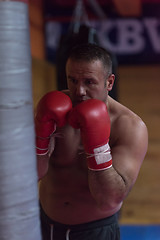 Image showing kick boxer training on a punching bag