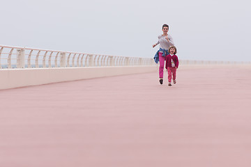 Image showing mother and cute little girl on the promenade by the sea