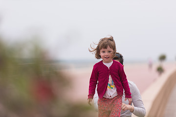 Image showing mother and cute little girl on the promenade by the sea