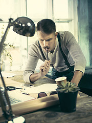 Image showing Architect working on drawing table in office