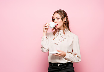 Image showing The serious frustrated young beautiful business woman on pink background