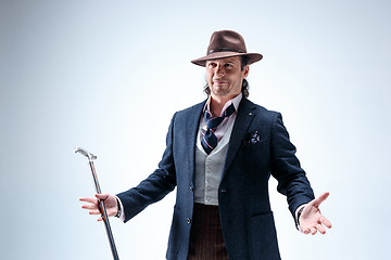 Image showing The mature man in a suit and hat holding cane.