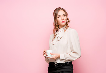 Image showing The serious frustrated young beautiful business woman on pink background