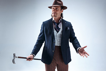 Image showing The mature man in a suit and hat holding cane.