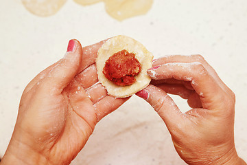 Image showing cook puts minced meat on dough