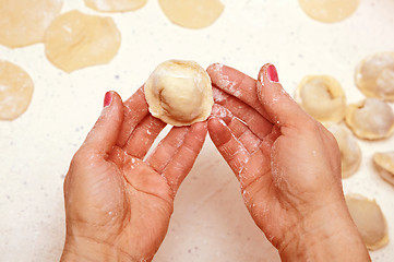 Image showing hands of cook with dumplings