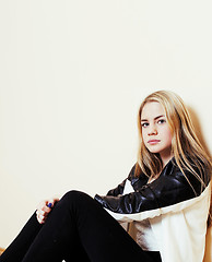 Image showing young pretty teenage blond girl sitting on floor at home despair