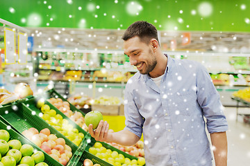 Image showing happy man buying green apples at grocery store