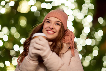 Image showing happy woman with coffee over christmas lights