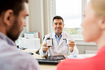 Image showing doctor showing medicine to family couple at clinic