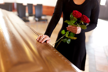 Image showing woman with red roses and coffin at funeral