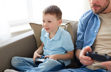 Image showing father and son playing video game at home