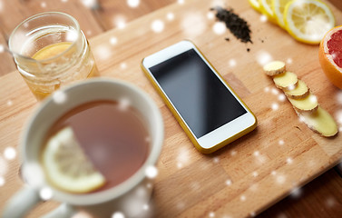 Image showing smartphone with cup of lemon tea, honey and ginger