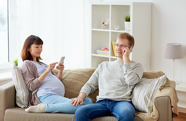 Image showing husband and pregnant wife with smartphone at home