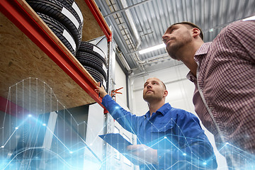 Image showing auto mechanic and man with tires at car shop