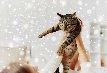 Image showing young woman with cat lying in bed at home