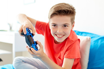 Image showing happy boy with gamepad playing video game at home