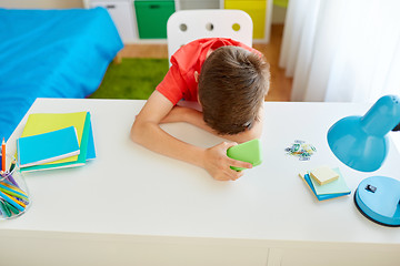 Image showing tired or sad student boy with smartphone at home