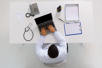 Image showing doctor with cardiogram and laptop at clinic