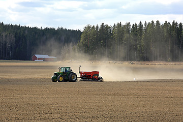 Image showing John Deere Tractor and Seeder on Spring Field